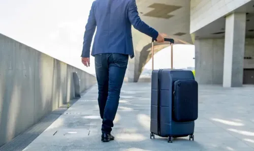 Man wearing a suit pulling his Kabuto luggage